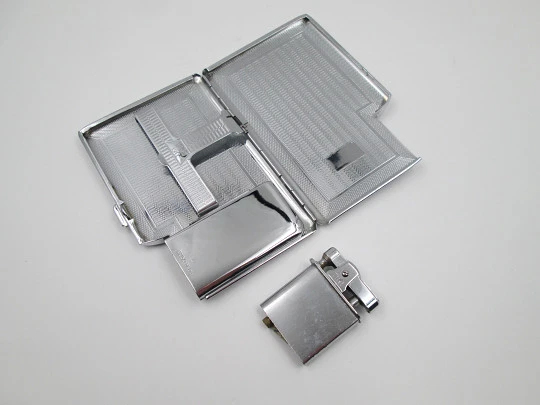Tiki cigarette case with petrol lighter. Silver plated metal. Waves motifs. England. 1960's