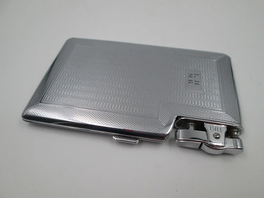 Tiki cigarette case with petrol lighter. Silver plated metal. Waves motifs. England. 1960's