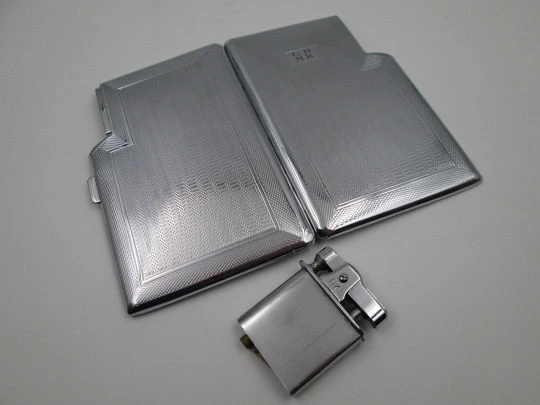 Tiki cigarette case with petrol lighter. Silver plated metal. Waves motifs. England. 1960's