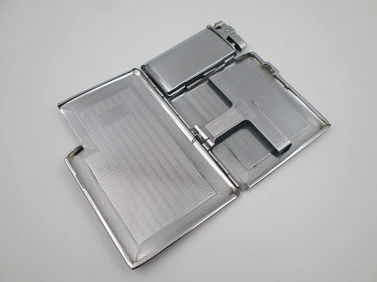 Tiki cigarette case with petrol lighter. Silver plated metal. Waves motifs. England. 1960's