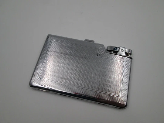Tiki cigarette case with petrol lighter. Silver plated metal. Waves motifs. England. 1960's