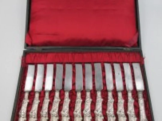 Twelve dessert knives boxed. Silver handles. Vegetable motifs. 1950's