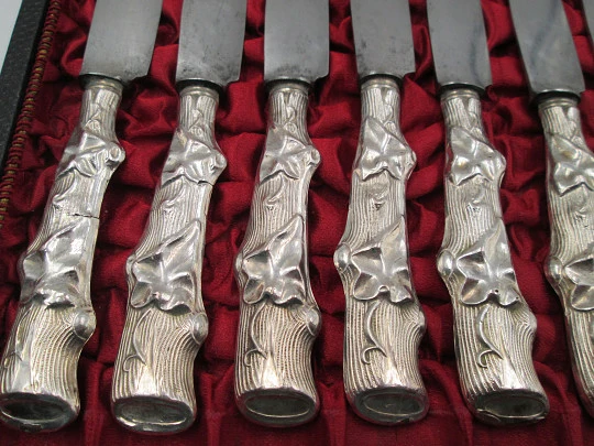 Twelve dessert knives boxed. Silver handles. Vegetable motifs. 1950's