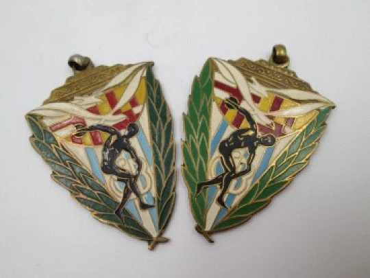 Two triangular sport medals. Gold plated metal and colours enamel. 1944. Spain
