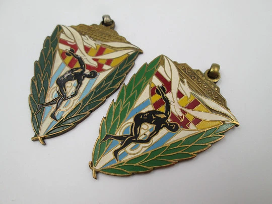 Two triangular sport medals. Gold plated metal and colours enamel. 1944. Spain