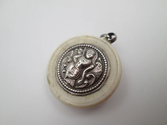 Unisex round pendant. Ivory paste & sterling silver. Warrion and saint relief. 1940's. Europe