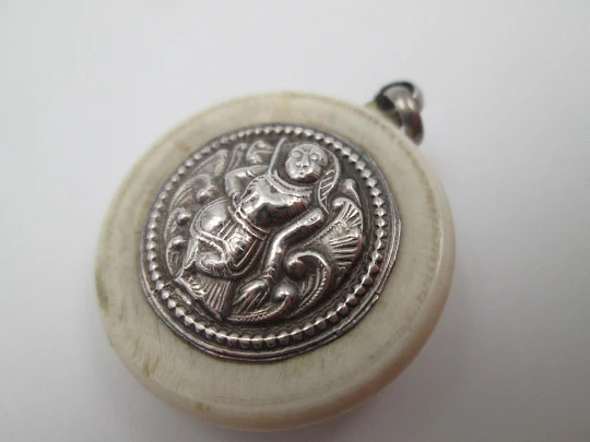Unisex round pendant. Ivory paste & sterling silver. Warrion and saint relief. 1940's. Europe