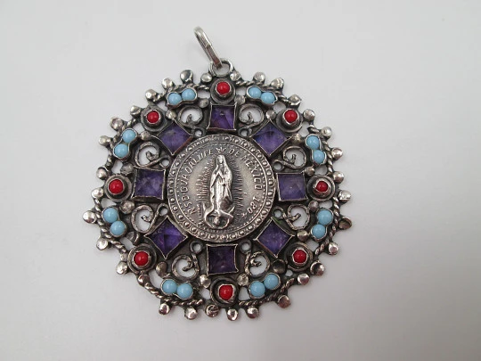 Virgin of Guadalupe pendant medal. Sterling silver. Amethysts, turquoise and coral. 1960's