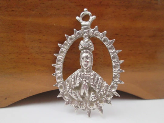 Virgin of the Tabernacle silver openwork medal. Sphere decorations and triangular edge. 1900's