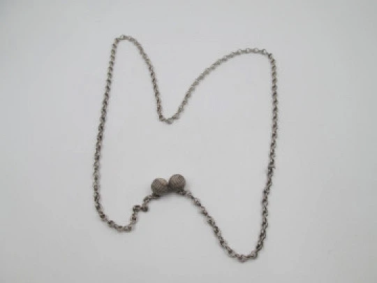 Woman necklace. Chain with links on eight. Ball ends with cord motif. 1950's. Europe