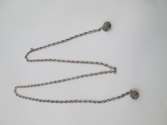 Woman necklace. Chain with links on eight. Ball ends with cord motif. 1950's. Europe