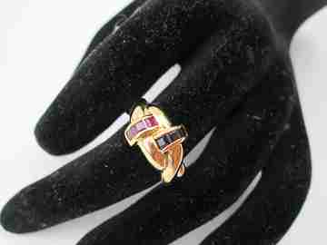 Women's loop ring. 18 karat yellow gold. Rubies and sapphires. 1980's. Europe