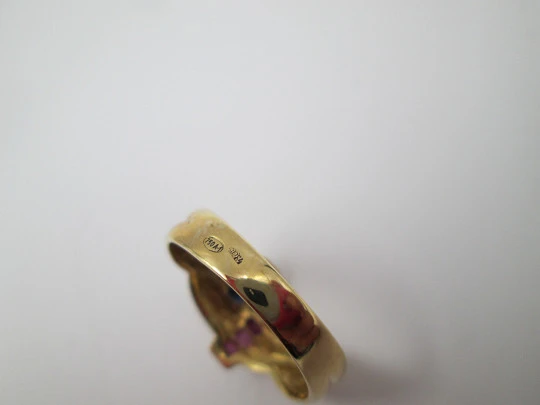 Women's loop ring. 18 karat yellow gold. Rubies and sapphires. 1980's. Europe