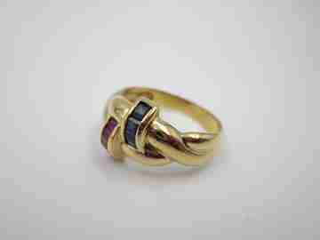 Women's loop ring. 18 karat yellow gold. Rubies and sapphires. 1980's. Europe