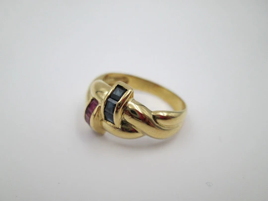 Women's loop ring. 18 karat yellow gold. Rubies and sapphires. 1980's. Europe