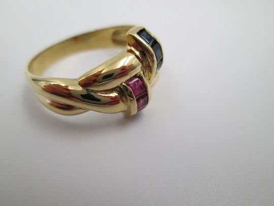 Women's loop ring. 18 karat yellow gold. Rubies and sapphires. 1980's. Europe