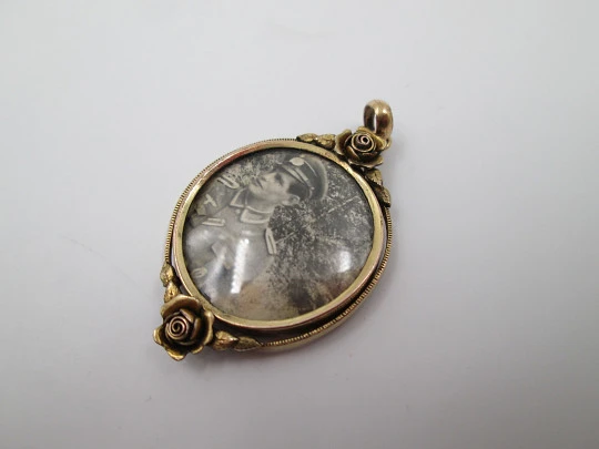 Women's low grade gold photo frame pendant. Floral motifs. Ring on top. 1930's