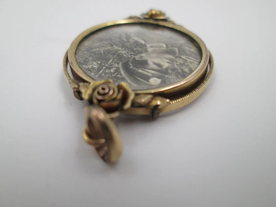 Women's low grade gold photo frame pendant. Floral motifs. Ring on top. 1930's