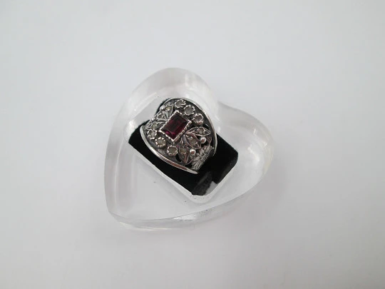 Women's openwork ring. Sterling silver, central garnet and white gems. 1990's