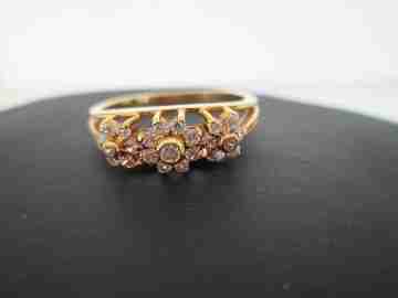 Women's ring. 18 karat yellow gold and three zircons flowers. Circa 1990's