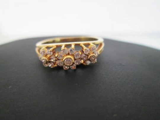 Women's ring. 18 karat yellow gold and three zircons flowers. Circa 1990's