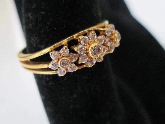 Women's ring. 18 karat yellow gold and three zircons flowers. Circa 1990's