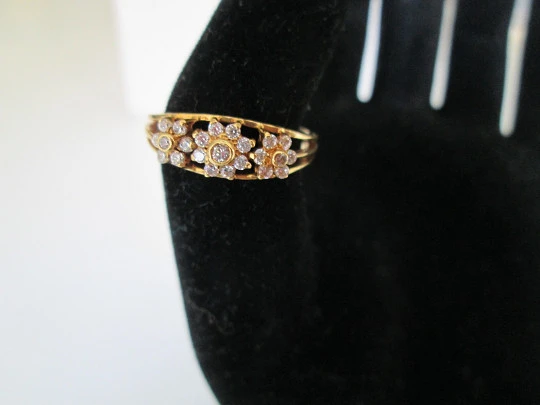 Women's ring. 18 karat yellow gold and three zircons flowers. Circa 1990's