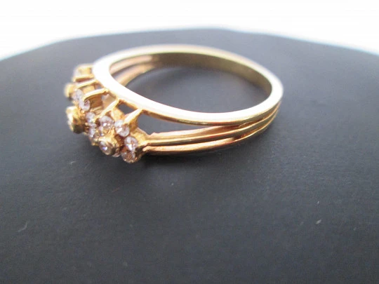 Women's ring. 18 karat yellow gold and three zircons flowers. Circa 1990's