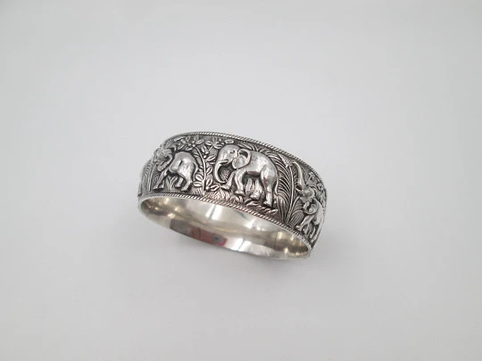 Women's wide bangle. Sterling silver. Elephants motifs on high relief. Europe. 1970's
