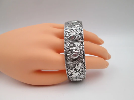 Women's wide bangle. Sterling silver. Elephants motifs on high relief. Europe. 1970's