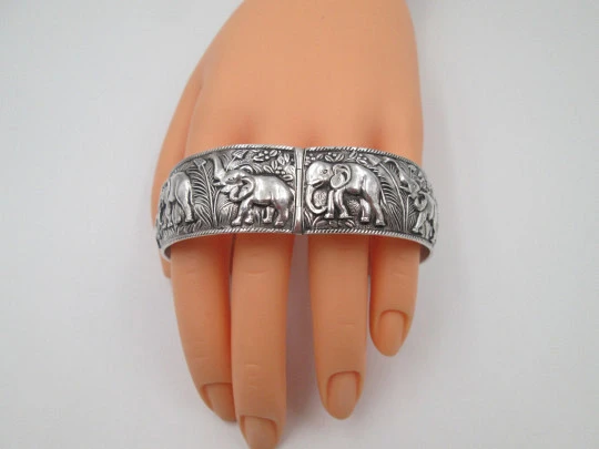 Women's wide bangle. Sterling silver. Elephants motifs on high relief. Europe. 1970's