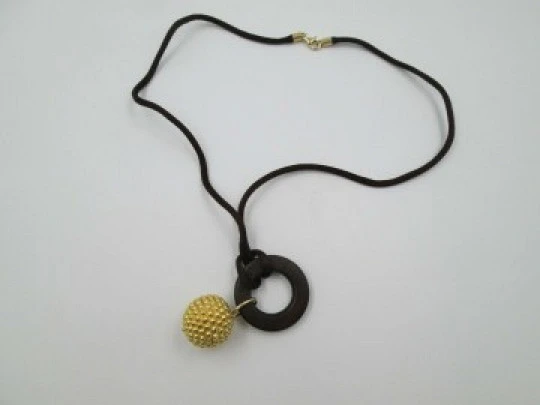 Yanes women's pendant. 18 karat yellow gold ball. Wood and silk cord