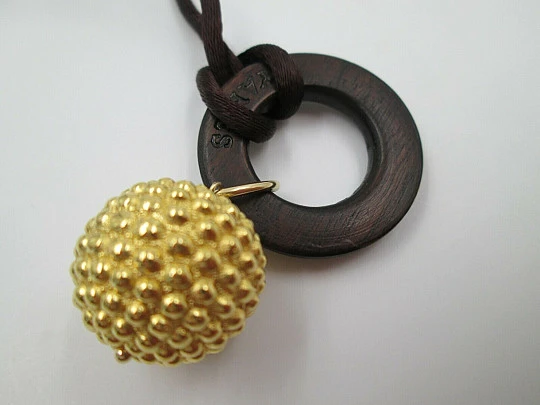 Yanes women's pendant. 18 karat yellow gold ball. Wood and silk cord