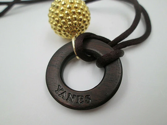 Yanes women's pendant. 18 karat yellow gold ball. Wood and silk cord