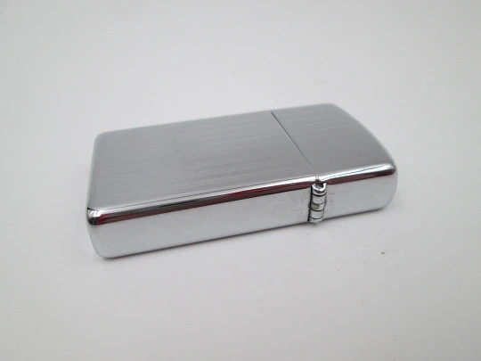 Zippo petrol pocket lighter. Chromed metal. Vertical lines pattern. United States. 1990's