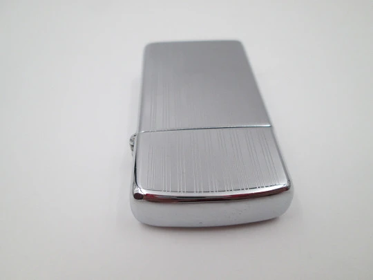 Zippo petrol pocket lighter. Chromed metal. Vertical lines pattern. United States. 1990's